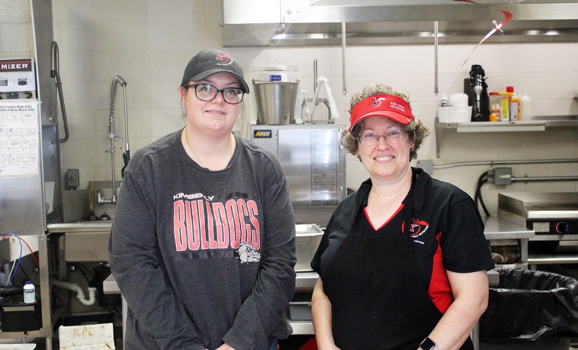 Food service specialists Amber Hartman (left) and Kelly Ramirez pose in the kitchen at Kimberly High School. | Photo by Noelia Juarez