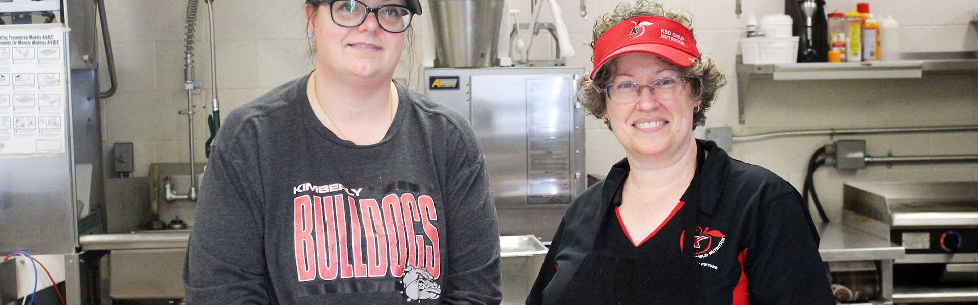 Food service specialists Amber Hartman (left) and Kelly Ramirez pose in the kitchen at Kimberly High School. | Photo by Noelia Juarez