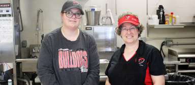 Food service specialists Amber Hartman (left) and Kelly Ramirez pose in the kitchen at Kimberly High School. | Photo by Noelia Juarez