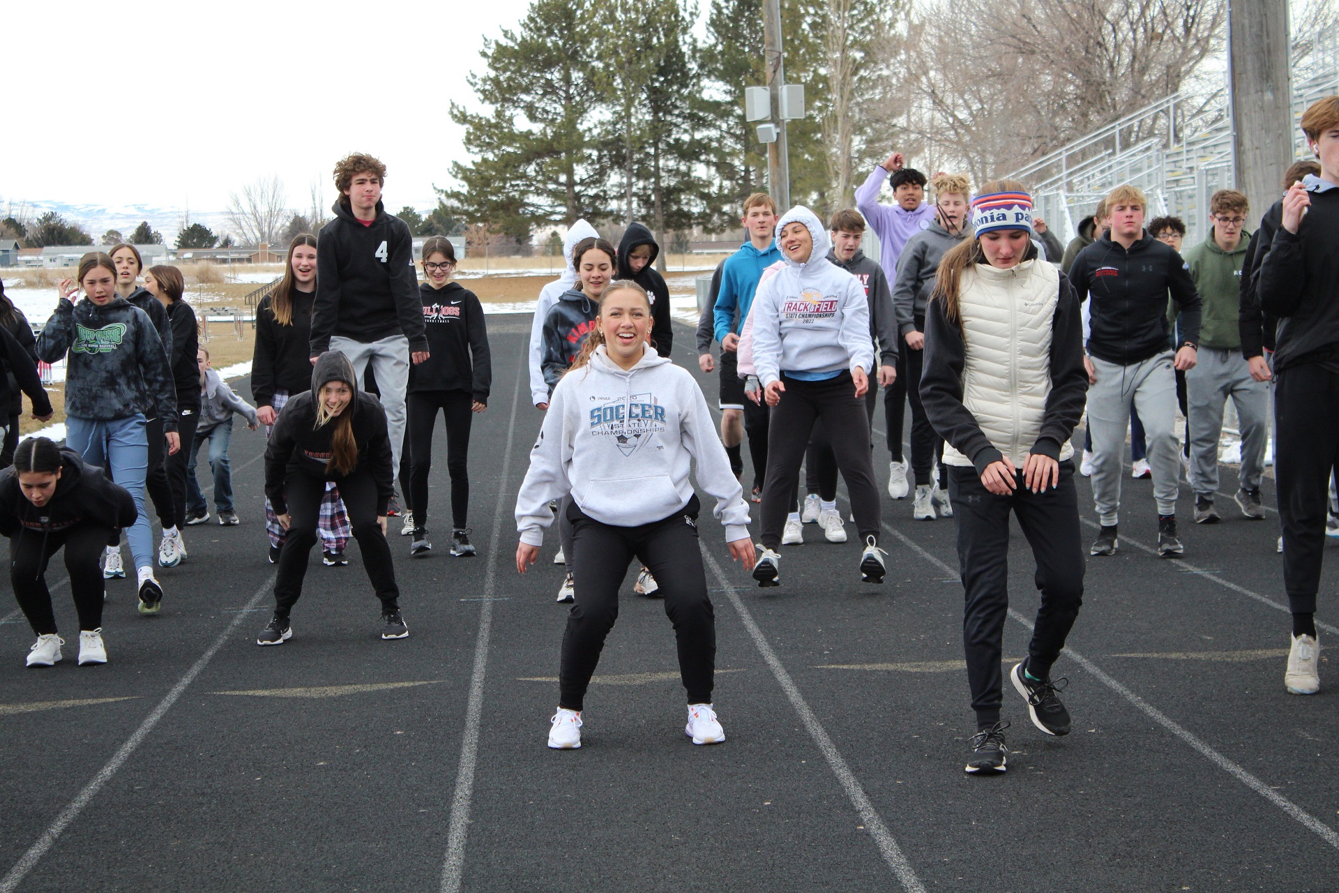 Senior Emily Ramirez and other members of the track and field team warm up during a cold practice this spring. | Photo by Kaya Thomas